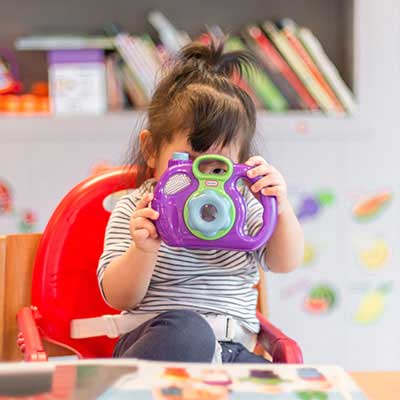 child holding camera